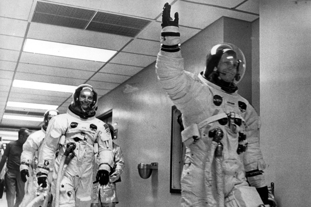 Posadka Apolla 11 na poti proti vesoljskemu plovilu, ki jih bo odpeljalo na Luno. Prvi Neil Armstrong, sledita mu Edwin 'Buzz' Aldrin in Michael Collins.