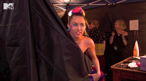 Miley Cyrus je med prenosom podelitve MTV nagrad takole kukala izza zavese, ko je v roke prijela mikrofon in ...