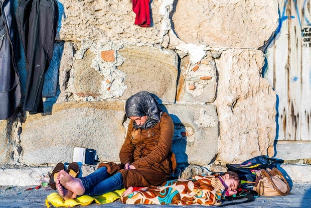 Do kosti premočena sirijska mama spi s svojim otrokom na ulicah grškega otoka Kos, po tem, ko sta preživela nevarno …