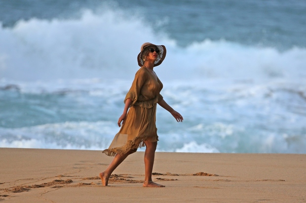 Beyonce se je ob sončnem zahodu psrehodila po plaži v čudoviti, lahkotni obleki v kaki barvi in z modnim klobukom. …