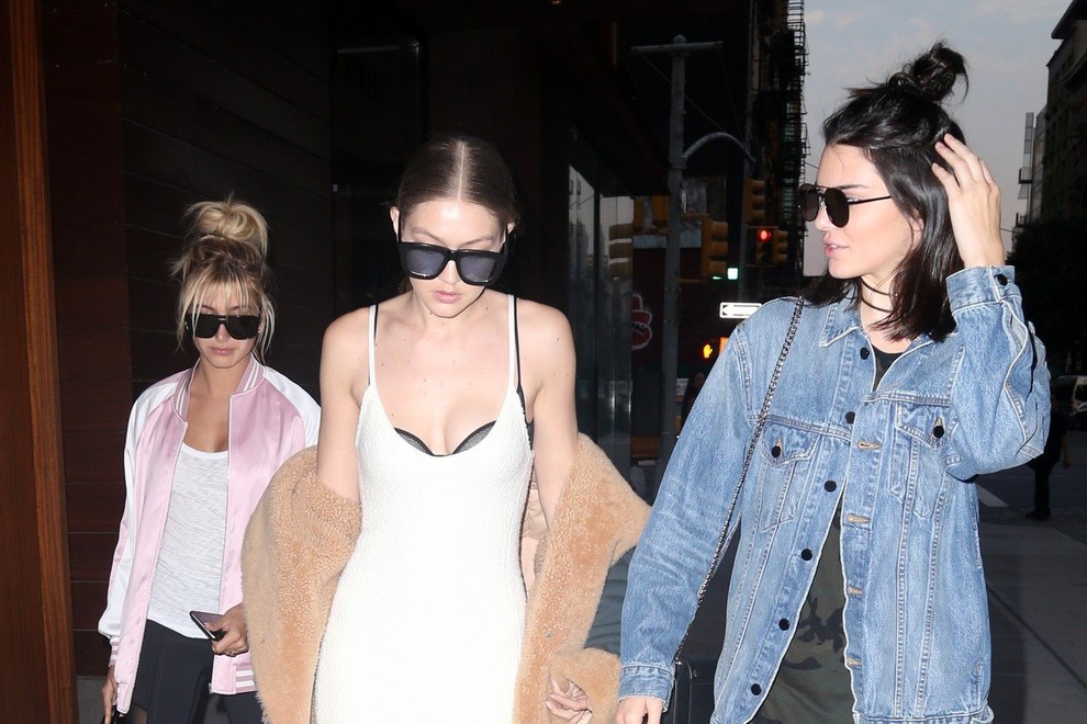 Gigi Hadid je svoj plašč pokombinirala z dolgo belo obleko.