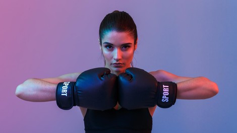 Photo of beautiful strong young sports woman make exercises with gym barbell disk isolated over purple wall background. Looking aside.