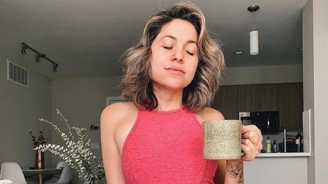 Ženska v rokah drži skodelico pijače