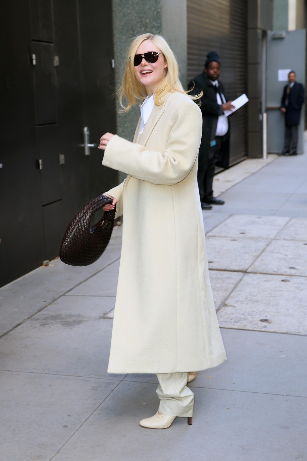 Da bi razbila mehko barvno paleto, je Fanning nosila pleteno usnjeno torbo znamke Bottega Veneta v temno čokoladni barvi. Videz …