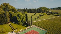 
                                                         Če radi vihtite lopar in lovite žogico, vas bo, ugnezden med vinogradi in s pogledom na bazen, v navdušenju pustilo teniško igrišče. Ob jutranji zarji je partija tenisa na črtasti zelenici fantastična rekreacija.